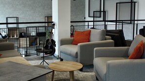 Una sala de estar moderna con sofás grises, una mesa de centro de madera y jaulas de metal negro.