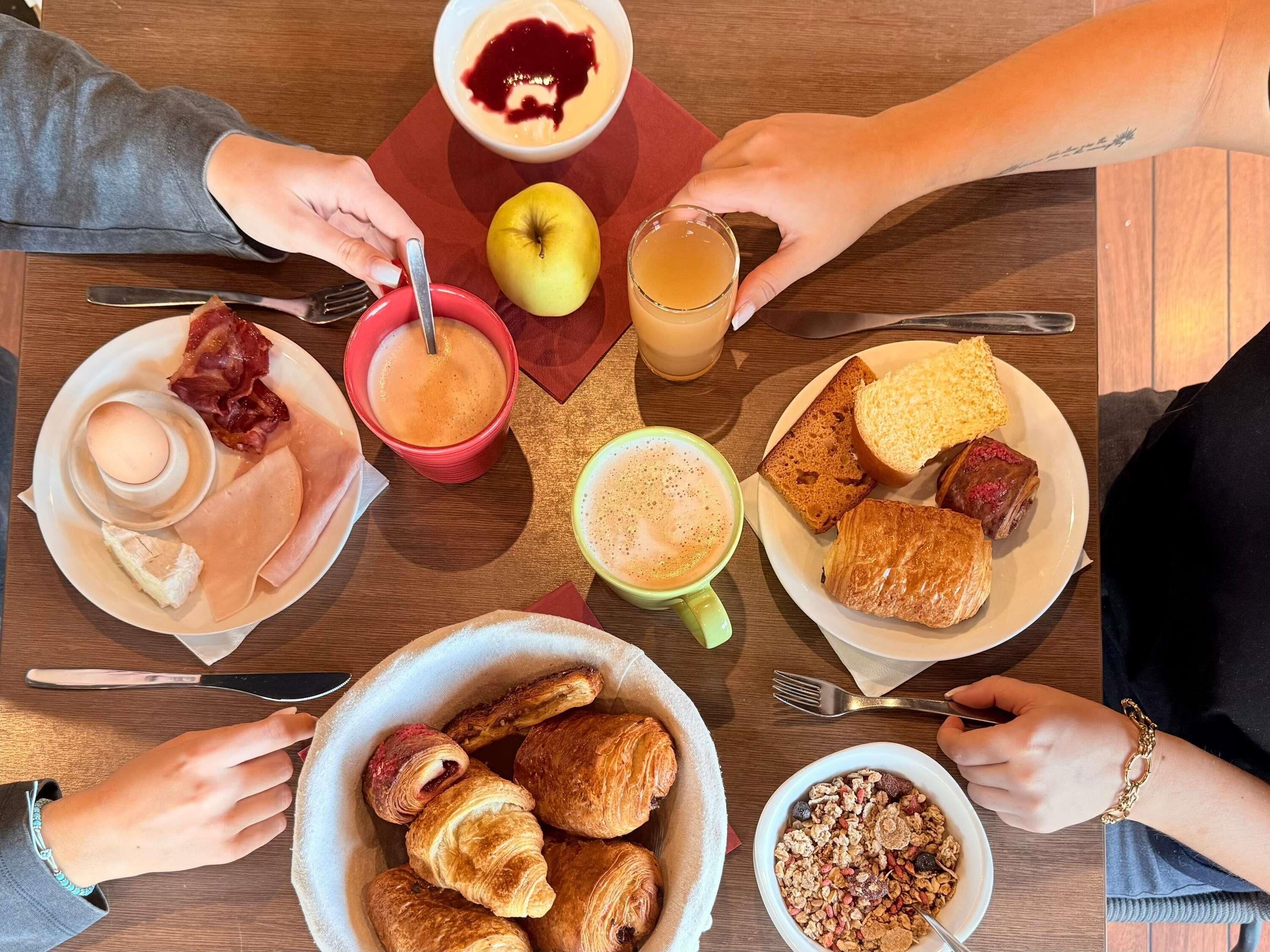 A breakfast setting with various food items and drinks on a table.