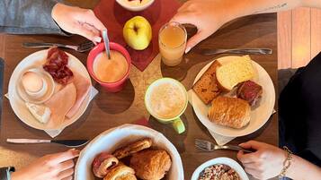 A breakfast setting with various food items and drinks on a table.