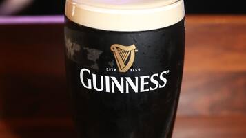 Un vaso de Guinness sobre una mesa de madera.