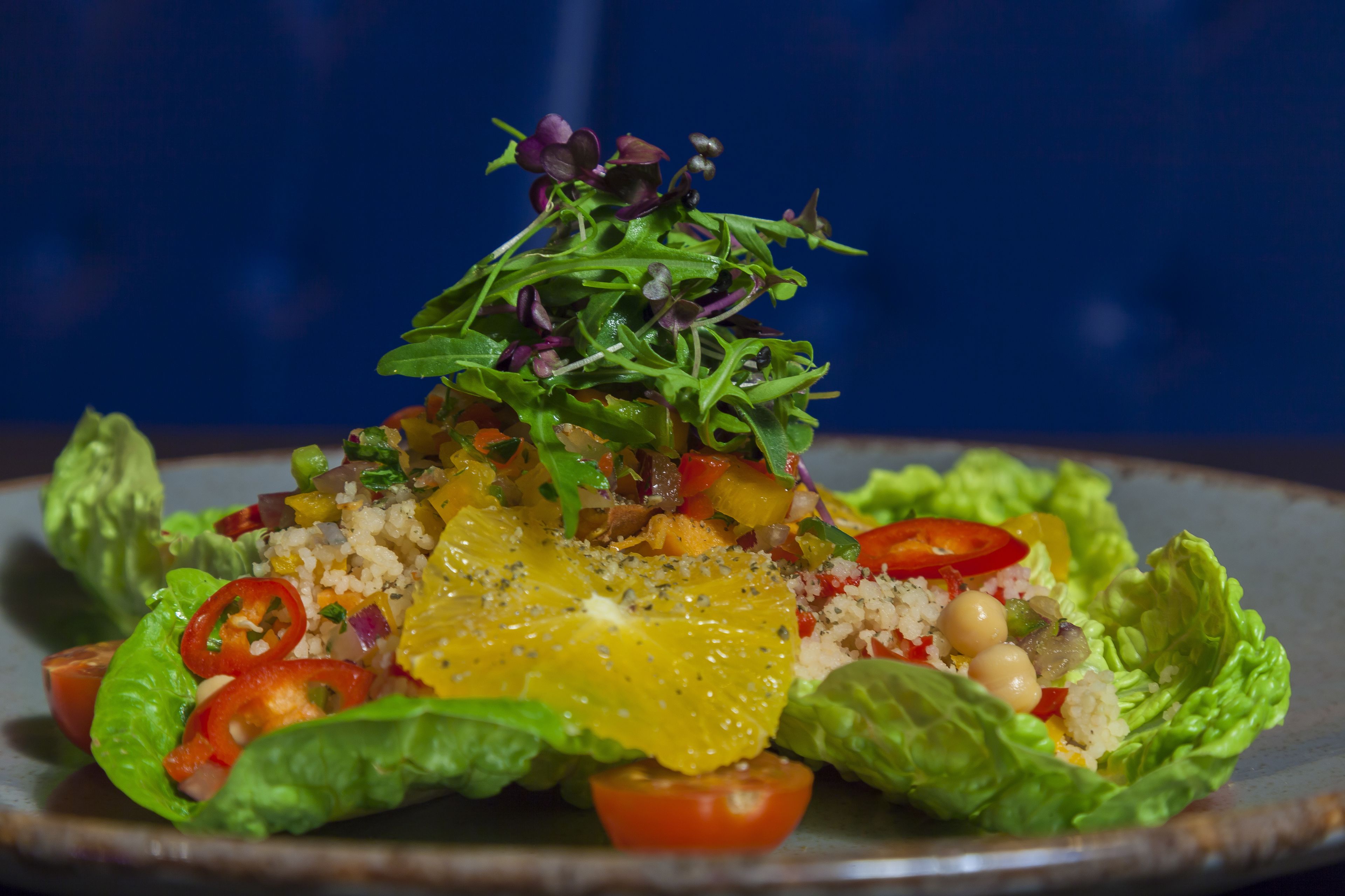 A salad with various vegetables and fruits on a plate.