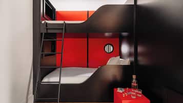 A bunk bed room with a ladder, a red table with bottles, and a round wall decoration.