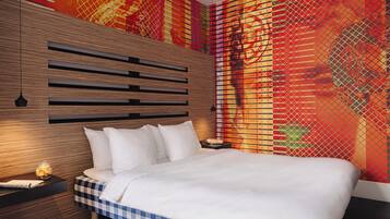 A modern bedroom with a wooden headboard, a checkered bedspread, and a vibrant abstract wall mural.