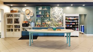 A modern kitchen with a central island, built-in shelves, and a variety of kitchen appliances.