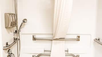 A modern bathroom with a shower, grab bars, and a bathtub.