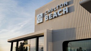 A building with the sign 'Carlton Beach' and a target symbol. - Carlton Beach (The Hague)