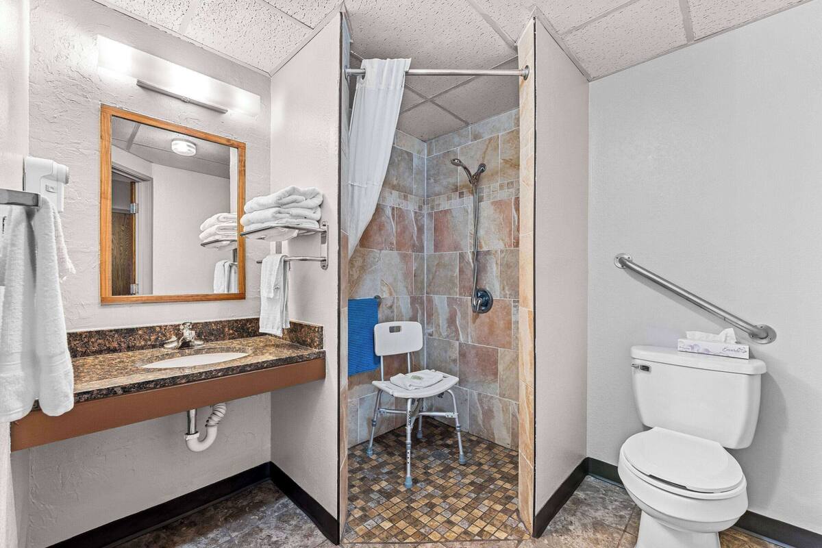 A bathroom with a shower, toilet, and sink.