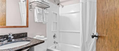 A bathroom with a sink, toilet, and bathtub.