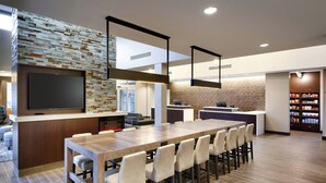 Una cucina moderna con una grande isola, elettrodomestici integrati e una TV a schermo piatto.