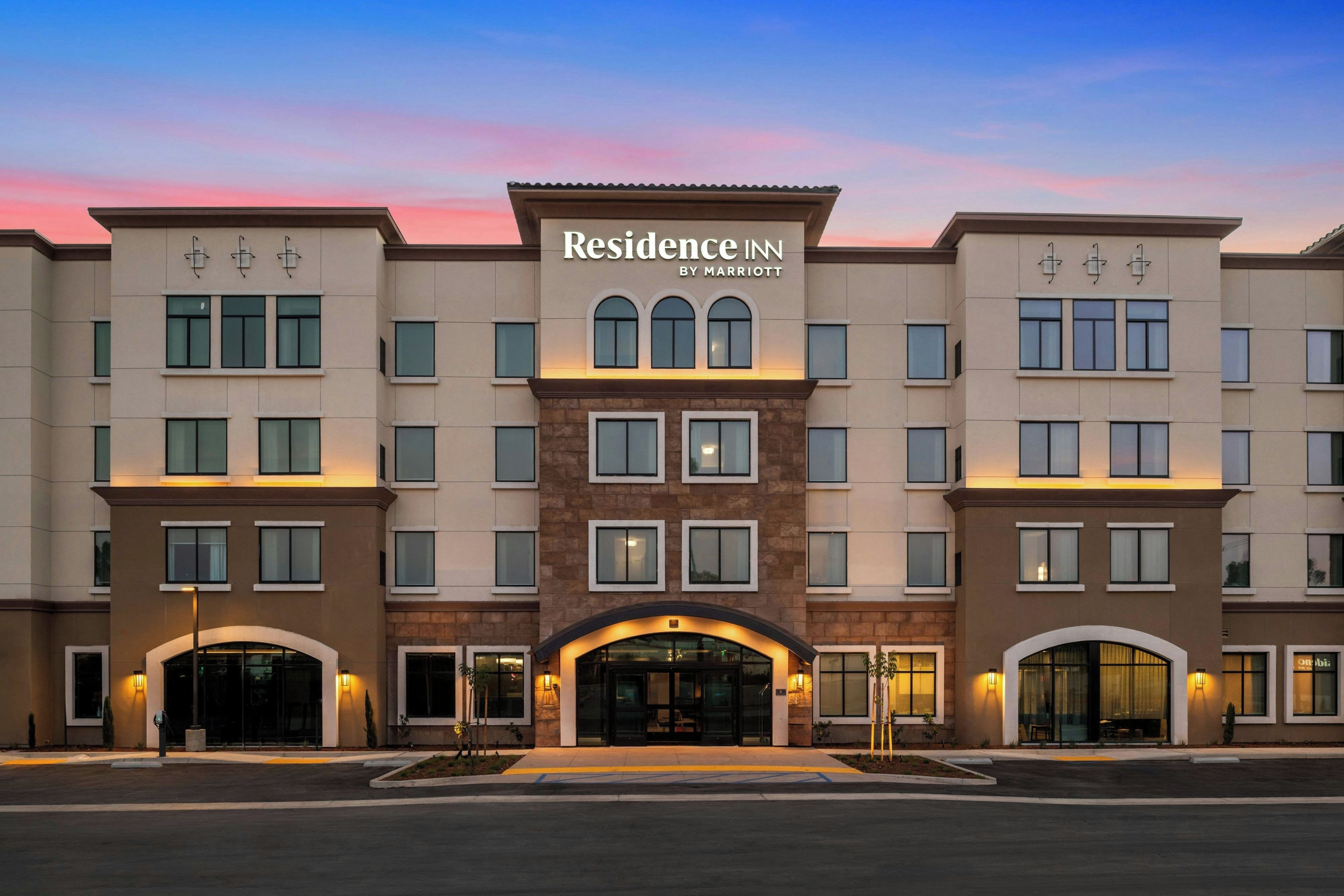 A multi-story hotel with a central entrance, large windows, and a sign indicating it's a Marriott property.