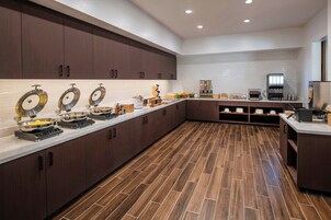 Una cocina moderna con una encimera amplia, equipada con diversos electrodomésticos y alimentos.