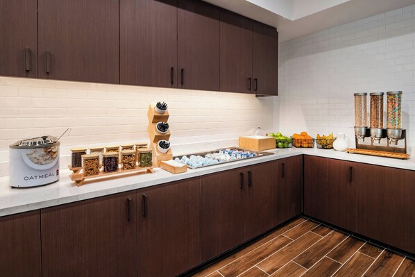 A modern kitchen with wooden cabinets, a white tiled backsplash, and various food storage containers.
