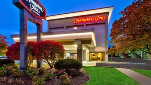 A Hampton Inn by Hilton hotel with a modern facade, illuminated signage, and landscaped grounds. - Hampton Inn Traverse City (Traverse City)