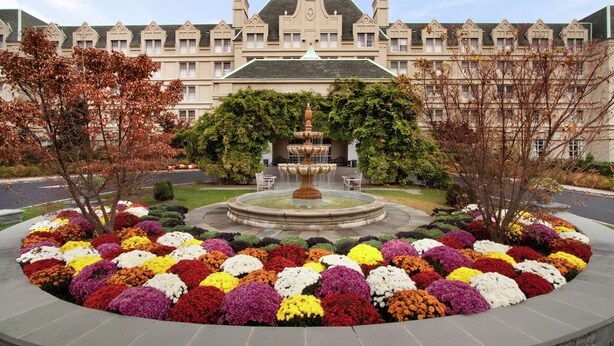 A large building with a fountain in the center surrounded by a circular flower bed. - Hilton Pearl River (Pearl River)