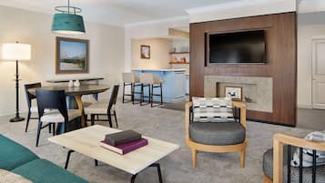 Ein modernes Wohnzimmer mit Essbereich, Kamin und Wand-Fernseher.