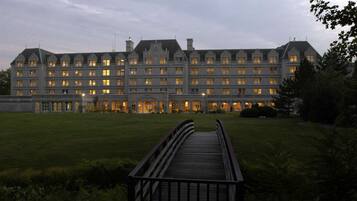 A large, multi-story hotel with a symmetrical facade, a central entrance, and a well-maintained lawn.