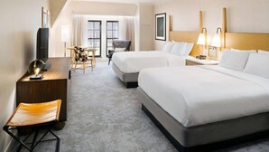 A hotel room with two beds, a desk with a chair, a TV, and a window with curtains. - Hilton Pearl River (Pearl River)