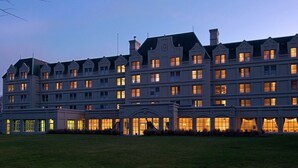 A large, multi-story hotel with a symmetrical facade, multiple windows, and a central entrance with a portico. - Hilton Pearl River (Pearl River)