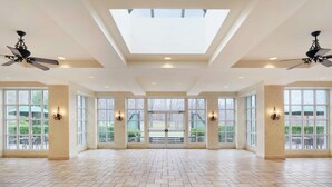 A spacious room with large windows, ceiling fans, and a skylight. - Hilton Pearl River (Pearl River)