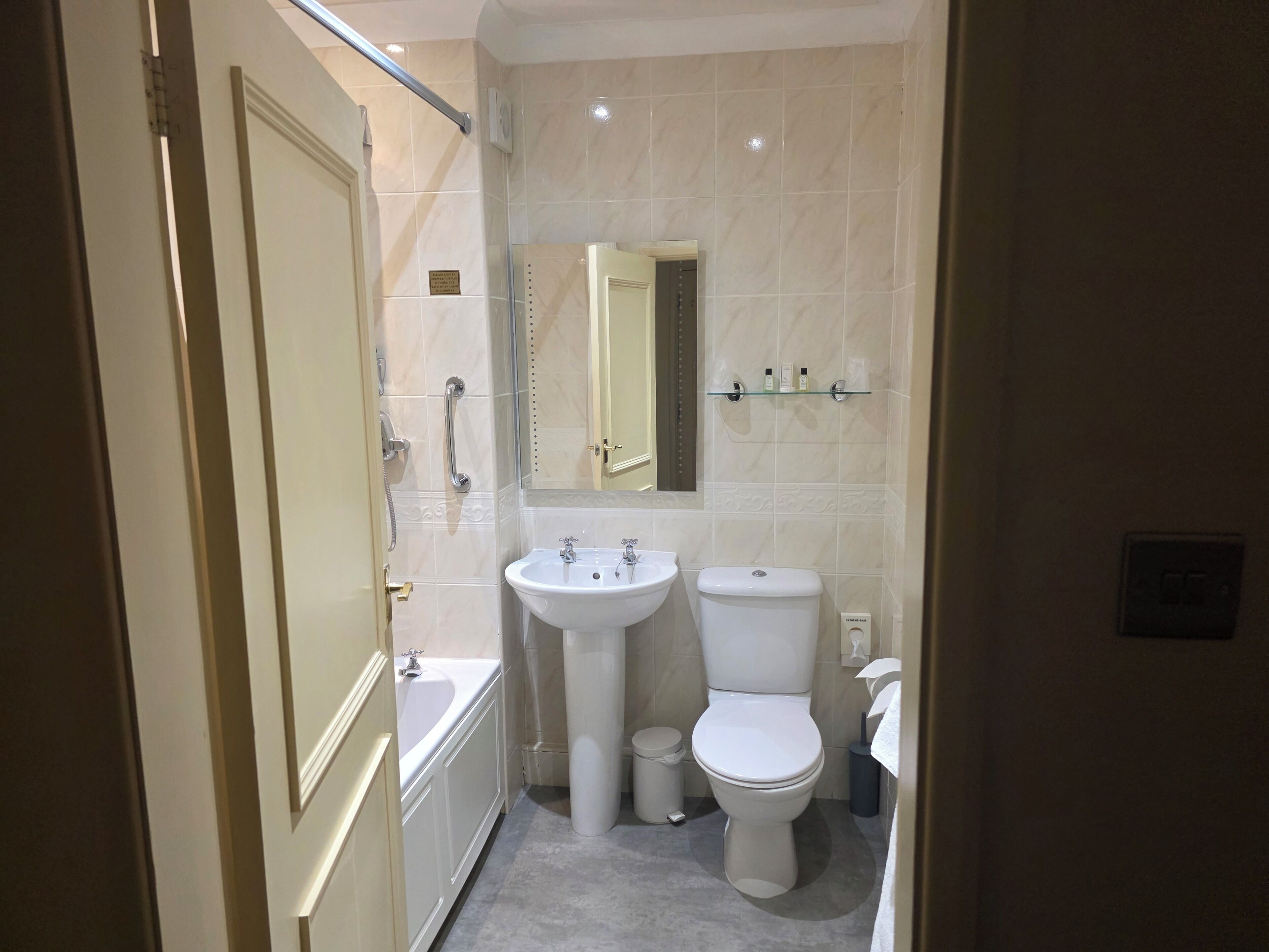 A compact bathroom with a bathtub, a sink, and a toilet.