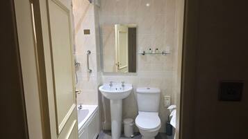 A compact bathroom with a bathtub, a sink, and a toilet.
