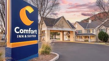 Señal de Comfort Inn & Suites con un diseño moderno, un estacionamiento techado y un edificio de estilo arquitectónico tradicional.