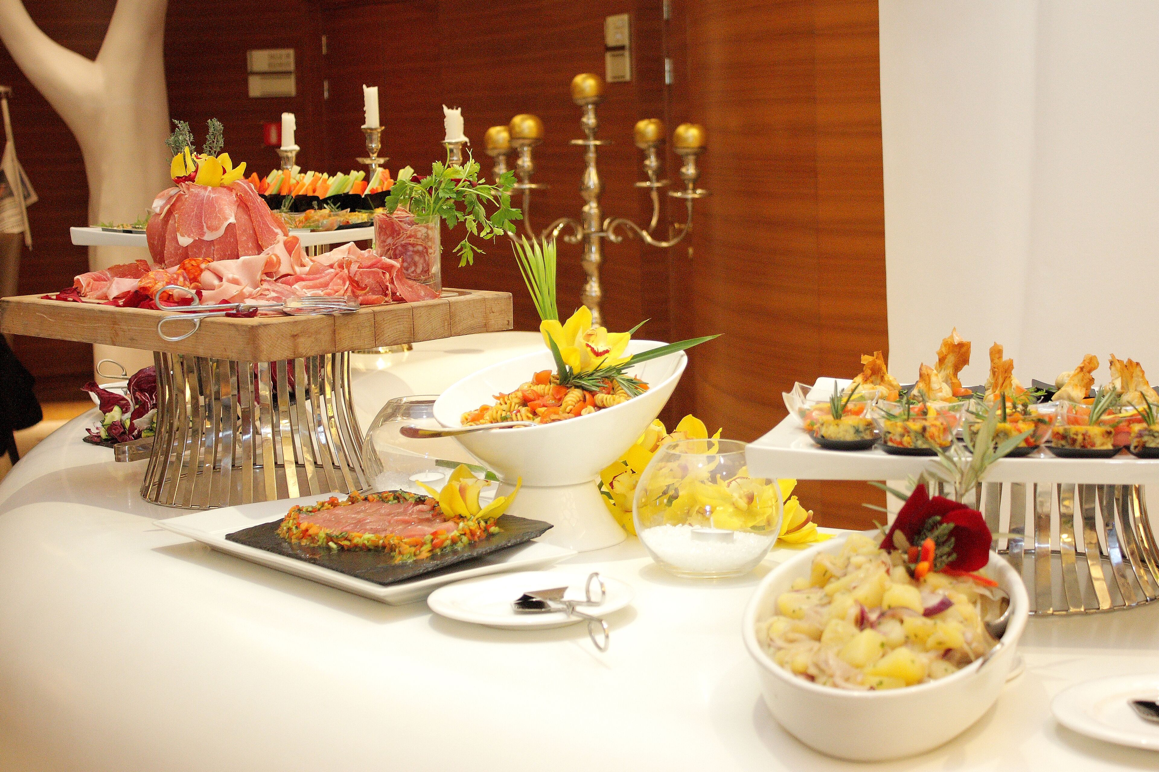 A buffet table with various dishes, including meats, salads, and appetizers.