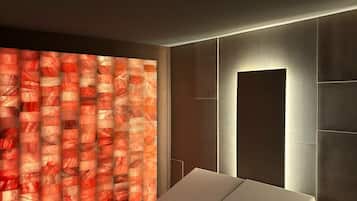 A modern room with a bed, a wall with a textured pattern, and a recessed ceiling light.