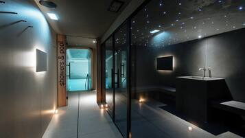 A modern bathroom with a glass partition, a sink, and a shower area.