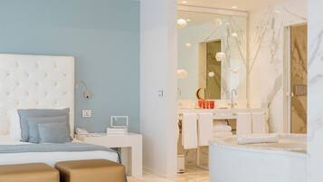 A modern bedroom with a tufted headboard, bedside table, and a large mirror.