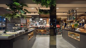 A modern kitchen with a central island, various kitchen appliances, and a chef preparing food.