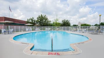 Een seizoensgebonden buitenzwembad en ligstoelen