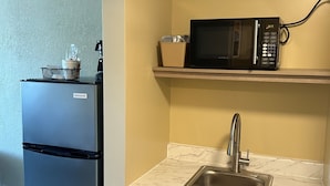 A compact kitchen with a refrigerator, microwave, sink, and a small trash bin. - Days Inn by Wyndham Gettysburg (Gettysburg)