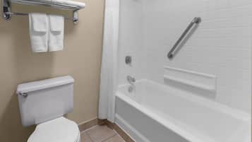 A bathroom with a toilet, a bathtub, and a shower area.