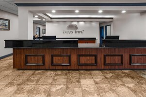 Una recepción con el logotipo de Days Inn, un diseño de paneles de madera y piso de baldosas.