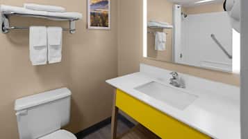 A bathroom with a toilet, a sink, a mirror, and a towel rack.
