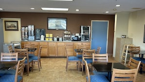 A restaurant with booths and tables, a coffee machine, and a television on the wall. - Days Inn by Wyndham Gettysburg (Gettysburg)