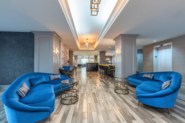 Relax in our spacious lobby, featuring a reception desk, bar, and comfortable seating areas.