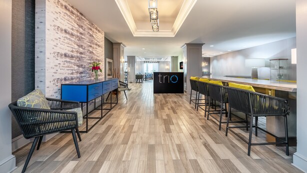 A modern kitchen with a bar area, wooden flooring, and a brick accent wall. - The Simon Hotel Sydney (Sydney)