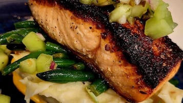 Un plato con salmón a la parrilla, judías verdes y puré de patatas.