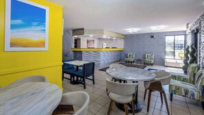 Ein modernes Interieur mit einer gelben Akzentwand, einem Marmortisch und einer Bar mit einer wellenförmigen Wandgestaltung.