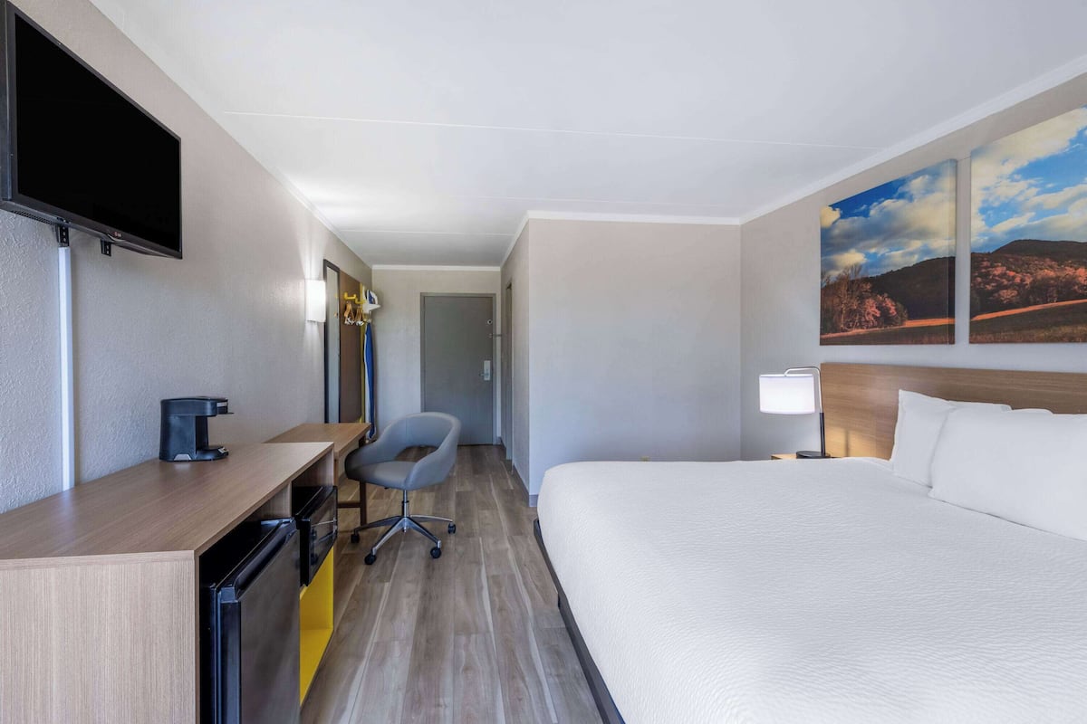 Escritorio, cortinas blackout y tabla de planchar con plancha