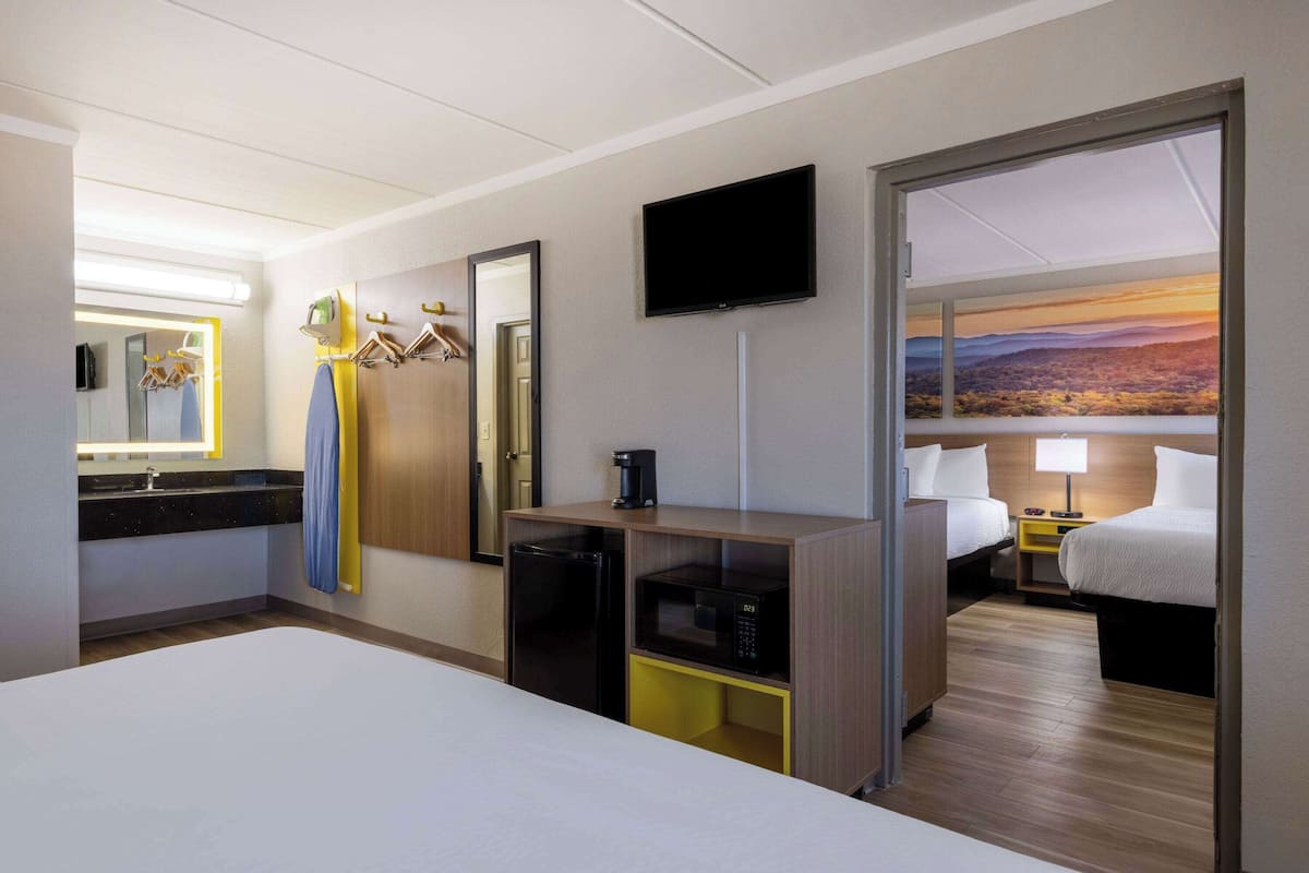 Escritorio, cortinas blackout y tabla de planchar con plancha