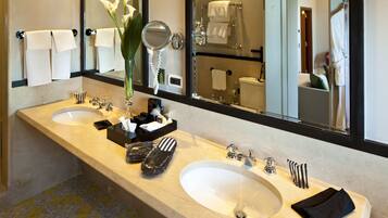 Un baño de hotel con dos lavamanos, un espejo grande y un perchero para toallas.