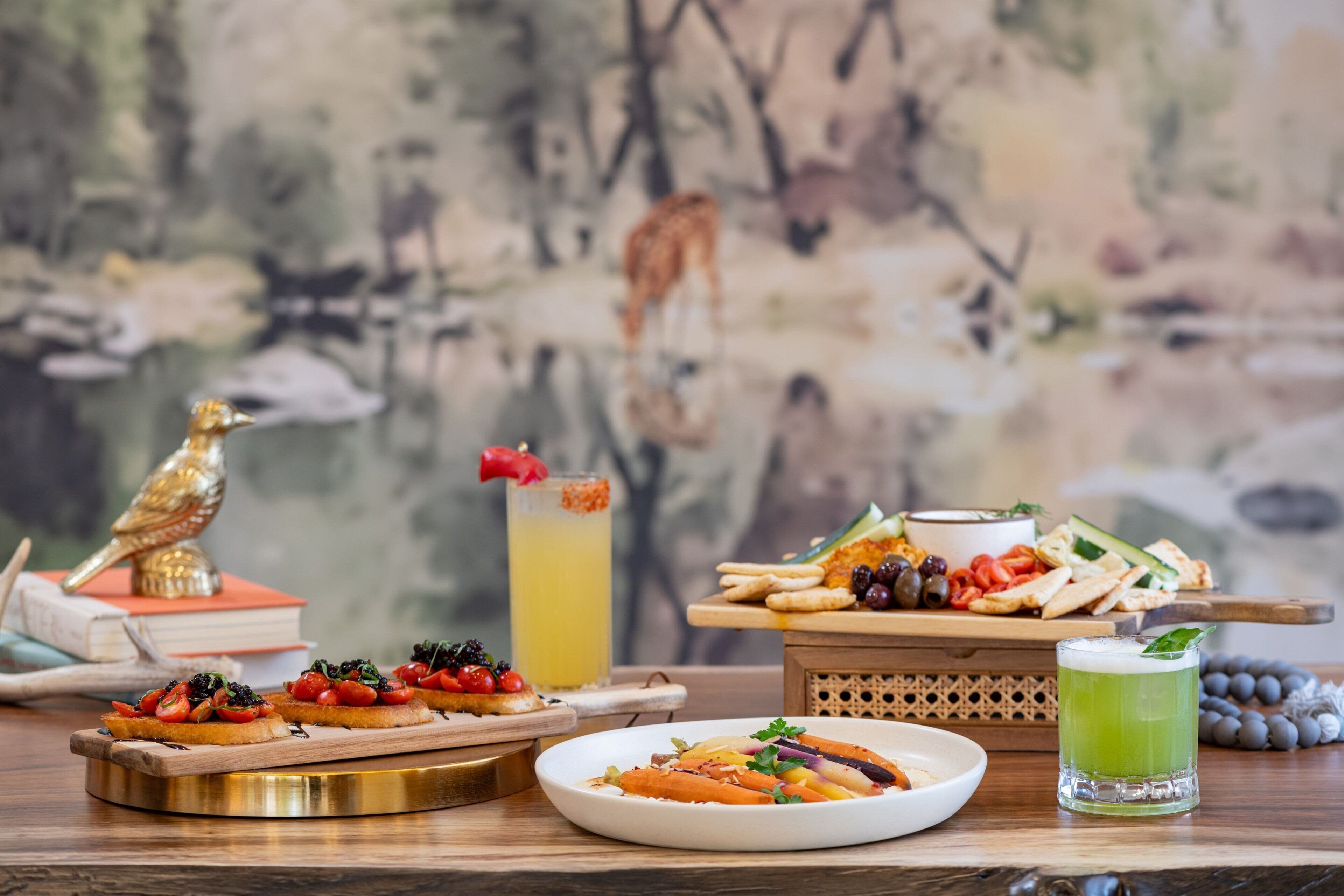 A table with various food items, a drink, and a decorative bird statue.