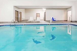 Una piscina techada, sillones reclinables de piscina