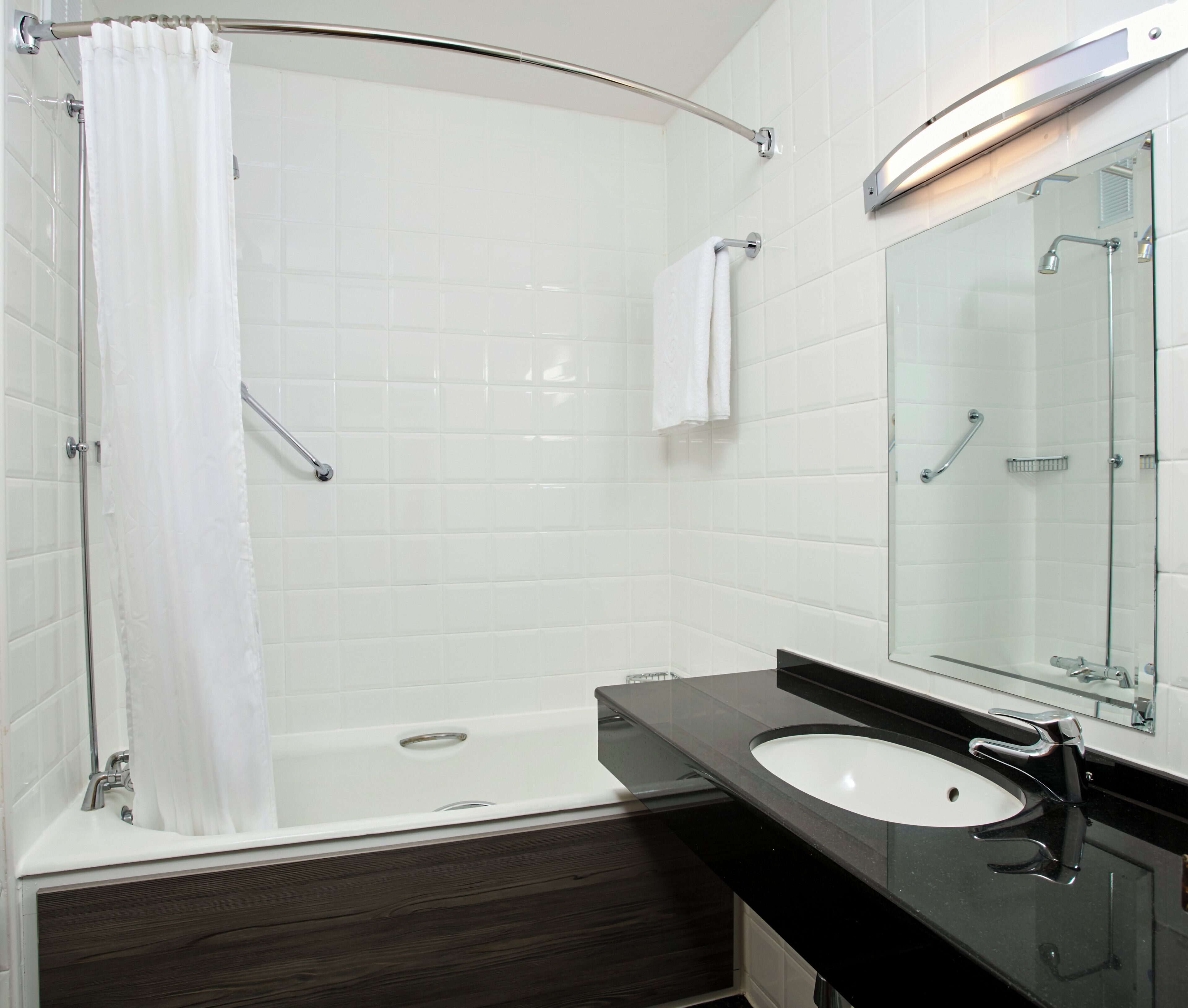 A modern bathroom with a shower, a sink, and a mirror.