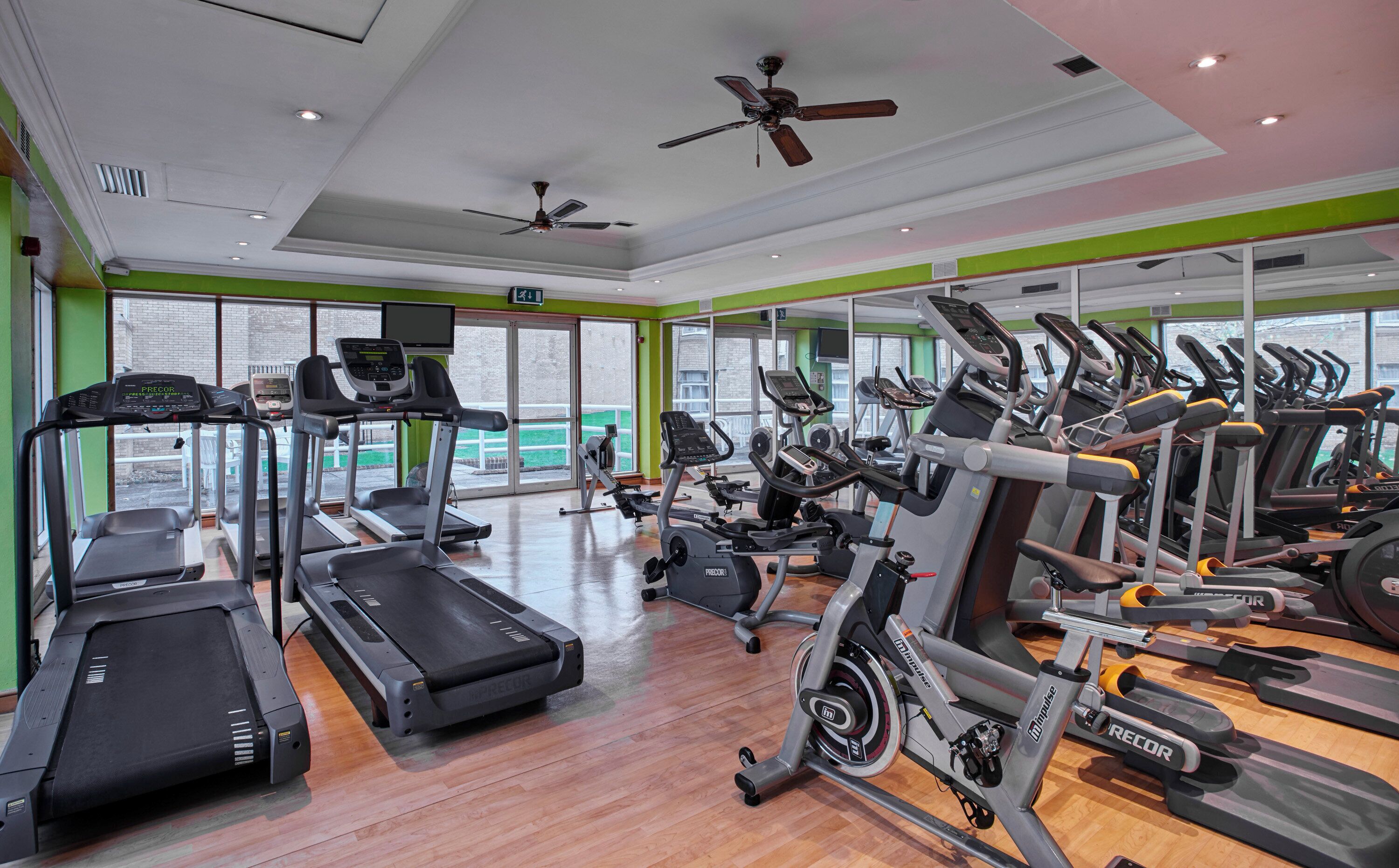 Un gimnasio con cintas de correr, bicicletas estáticas y máquinas elípticas.