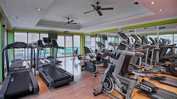 Un gimnasio con cintas de correr, bicicletas estáticas y máquinas elípticas.