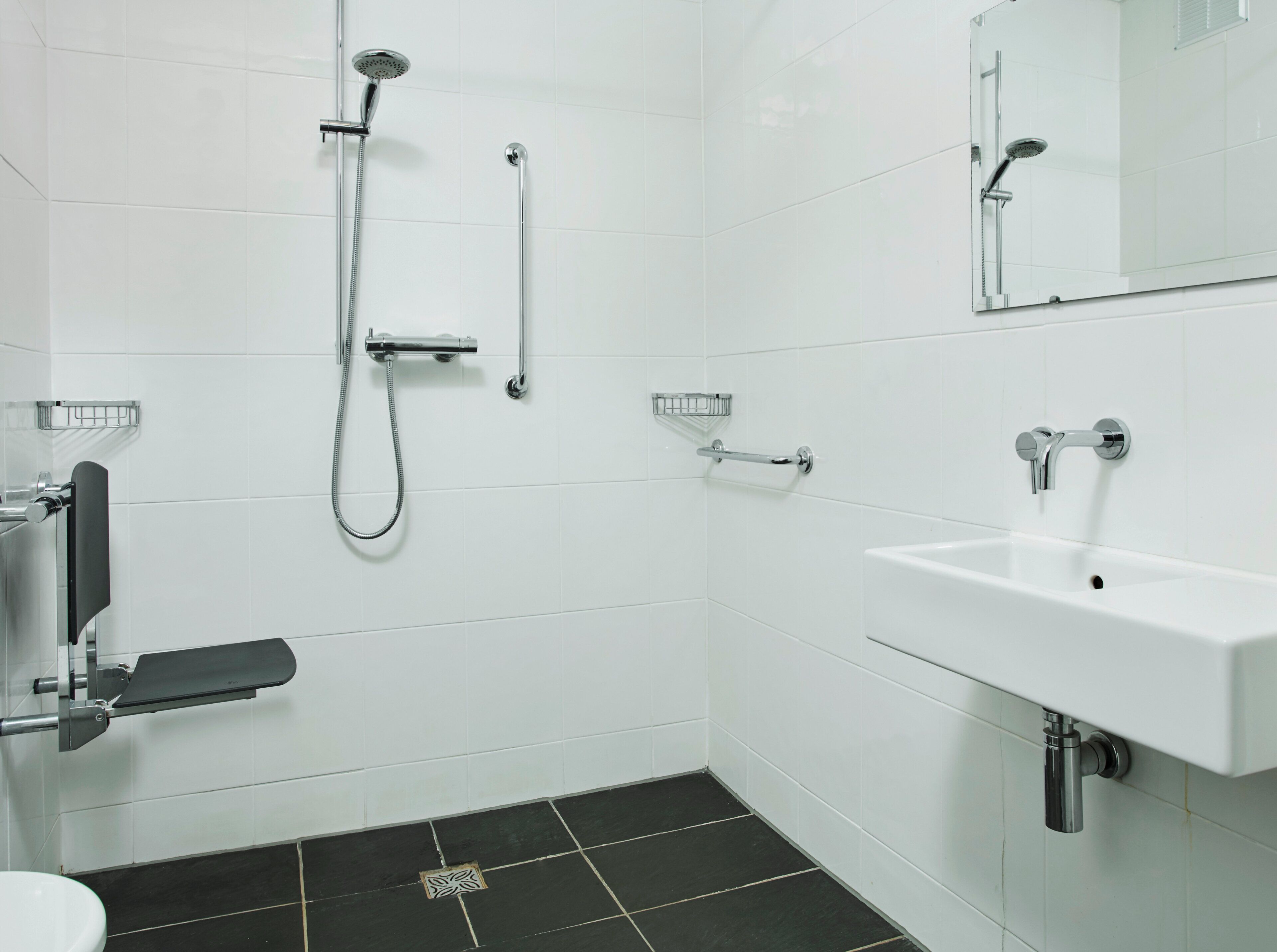 A modern bathroom with a shower, toilet, and sink.